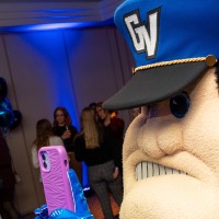 Louie the Laker takes someone's picture with a pink phone case